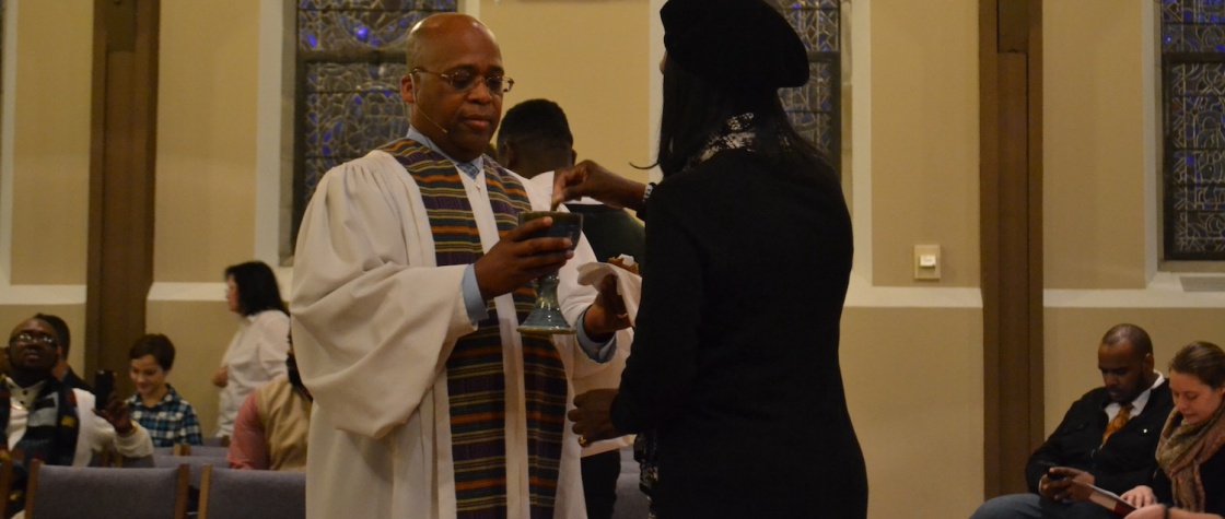 pastor giving communion to a studuent