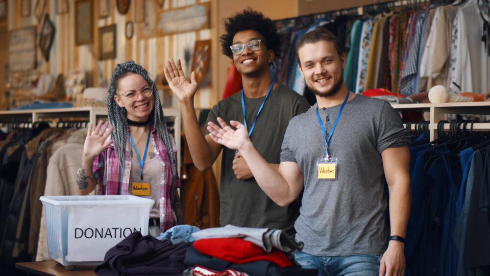 Portrait of young diverse volunteer group with clothes for donation