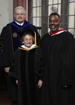 2012 Distinguished Alum award winners Dennis M. Oglesby Jr. and Phyllis Kohl Coston stand next to Garrett-Evangelical's president. All three people are wearing graduation robes.