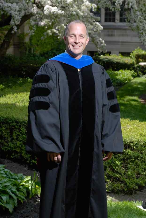 Distinguished Alum 2008 Jeffery R. Docking stands in a garden on Garrett-Evangelical's campus. He is wearing graduation robes.