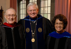 2009 Distinguished Alum award winners Ann E. Streaty Wimberly and Noel Dwight Osborn stand next to Garrett-Evangelical's president. All three people are wearing graduation robes.