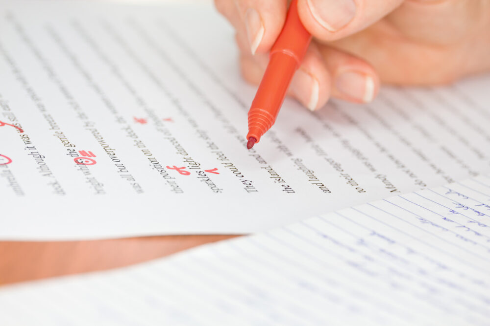 Hand with Red Pen Proofreading a Story